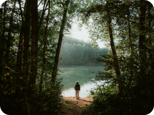 Person under festival tent overlooking lake at sunset
