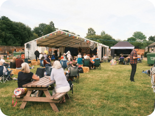 Person standing at edge of forest lake at golden hour
